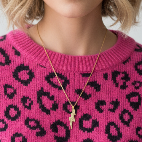 Woman wearing a pink sweater with black leopard print pattern against a white background
