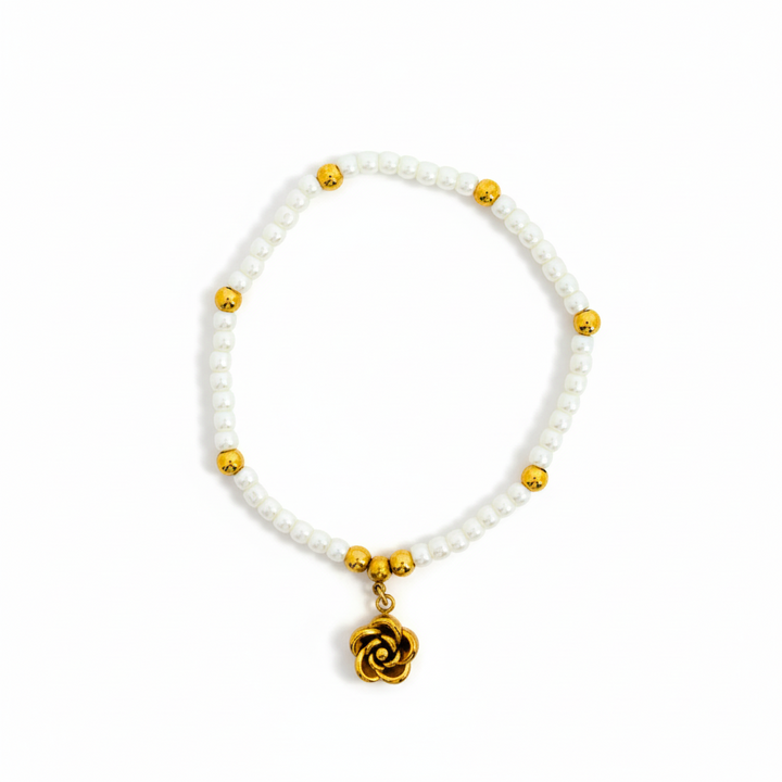 Bracelet with white beads and gold accents on a white background