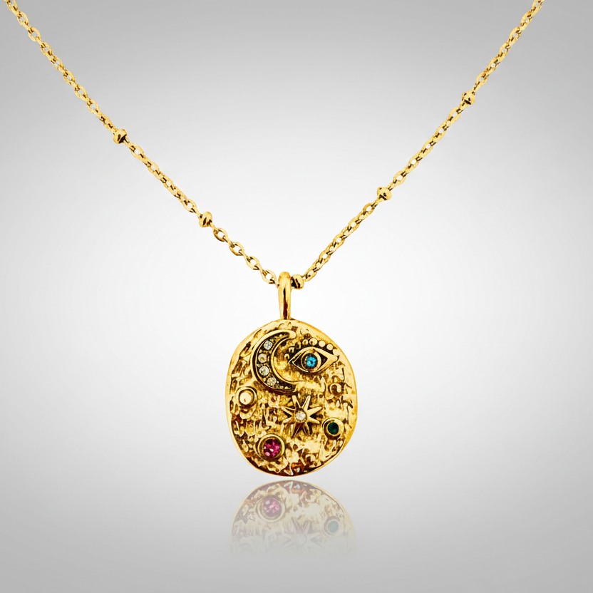 Gold necklace with a round pendant featuring gemstones on a white background