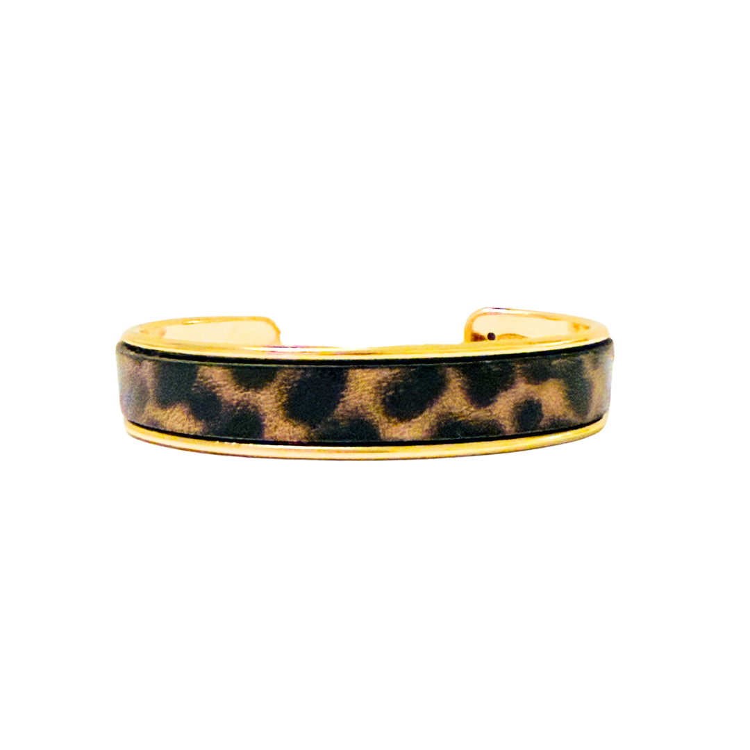Leopard print cuff bracelet with gold accents on a white background