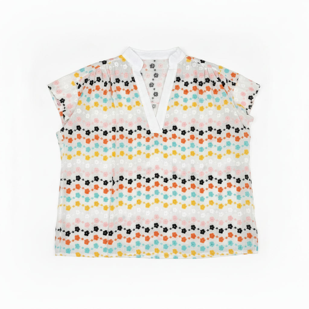 Floral blouse on a hanger against a wooden panel background