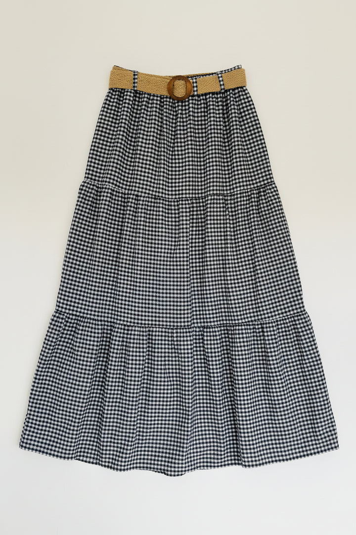 Black and white checkered skirt with a belt on a hanger against a white background