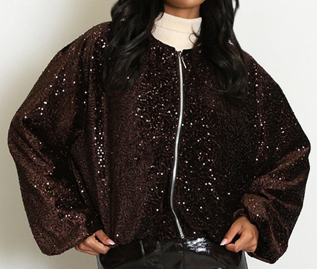 Woman wearing a black sequin jacket and vinyl skirt on a white background