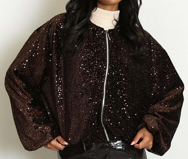 Woman wearing a black sequin jacket and vinyl skirt on a white background