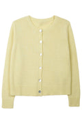 Light yellow cardigan with buttons on a white background