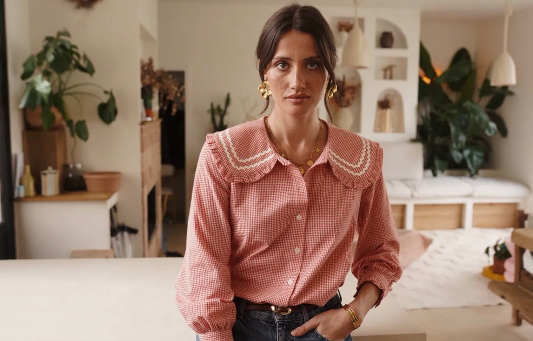 Woman wearing a pink checkered shirt in a home setting