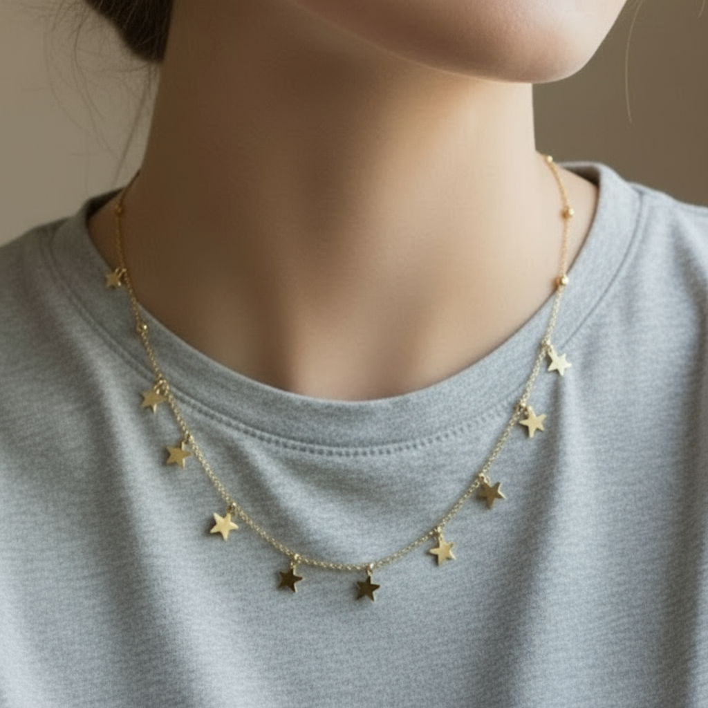 Gold star necklace worn by a person on a light gray shirt