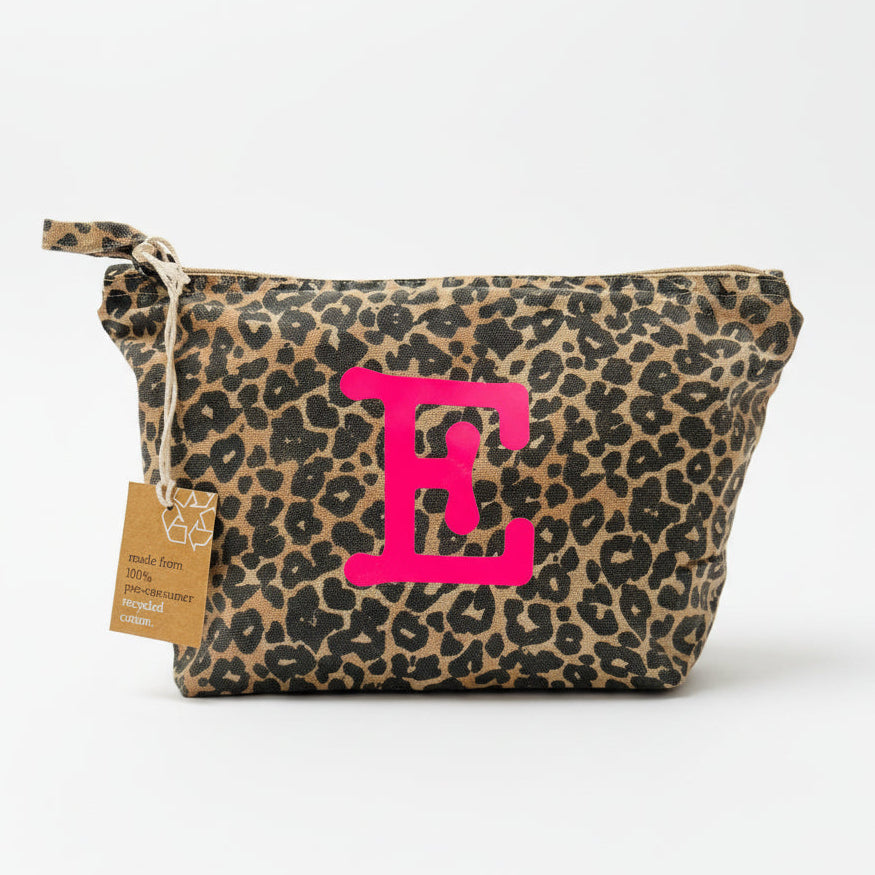 Leopard print pouch with pink 'E' and a tag on a white surface