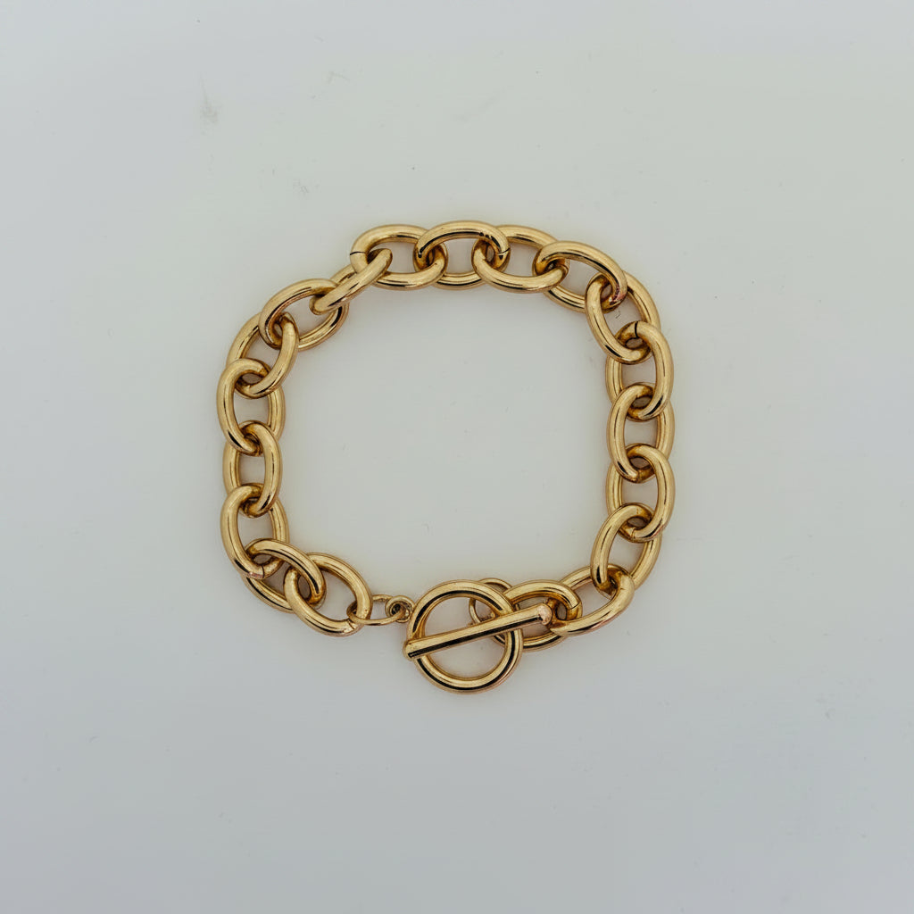 A gold-toned metal chain bracelet with a toggle clasp, photographed on a plain light background.