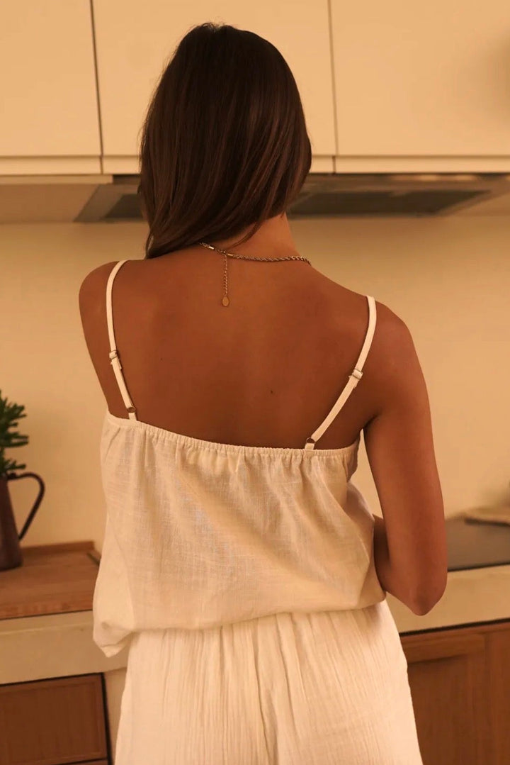 Woman in a white outfit standing in a kitchen
