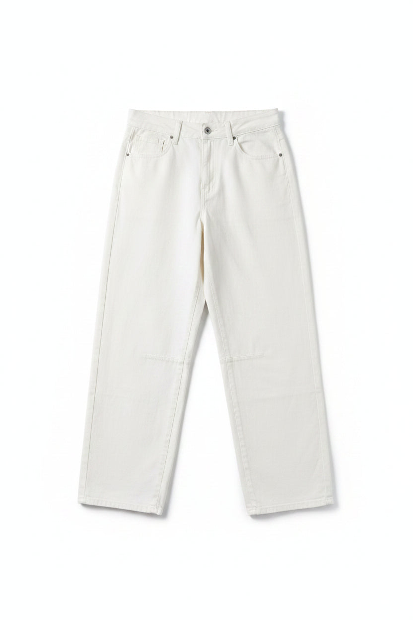 A pair of off-white or cream-colored denim jeans hanging from a black hanger against a pink and red vertically striped background.