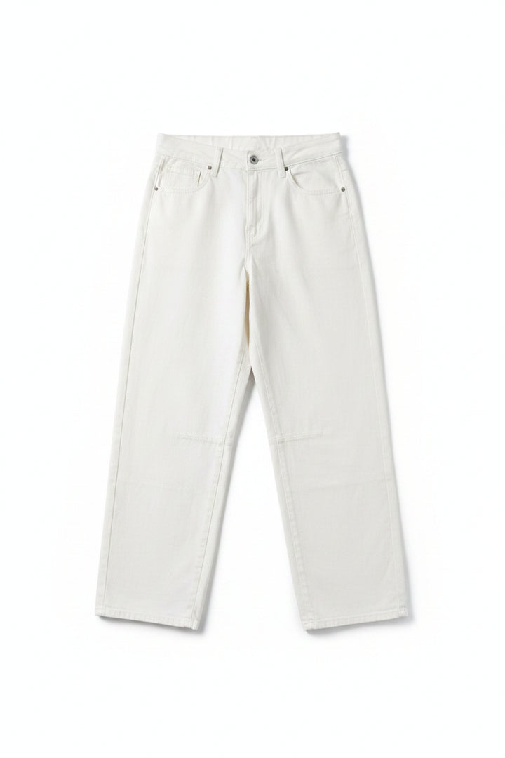 A pair of off-white or cream-colored denim jeans hanging from a black hanger against a pink and red vertically striped background.