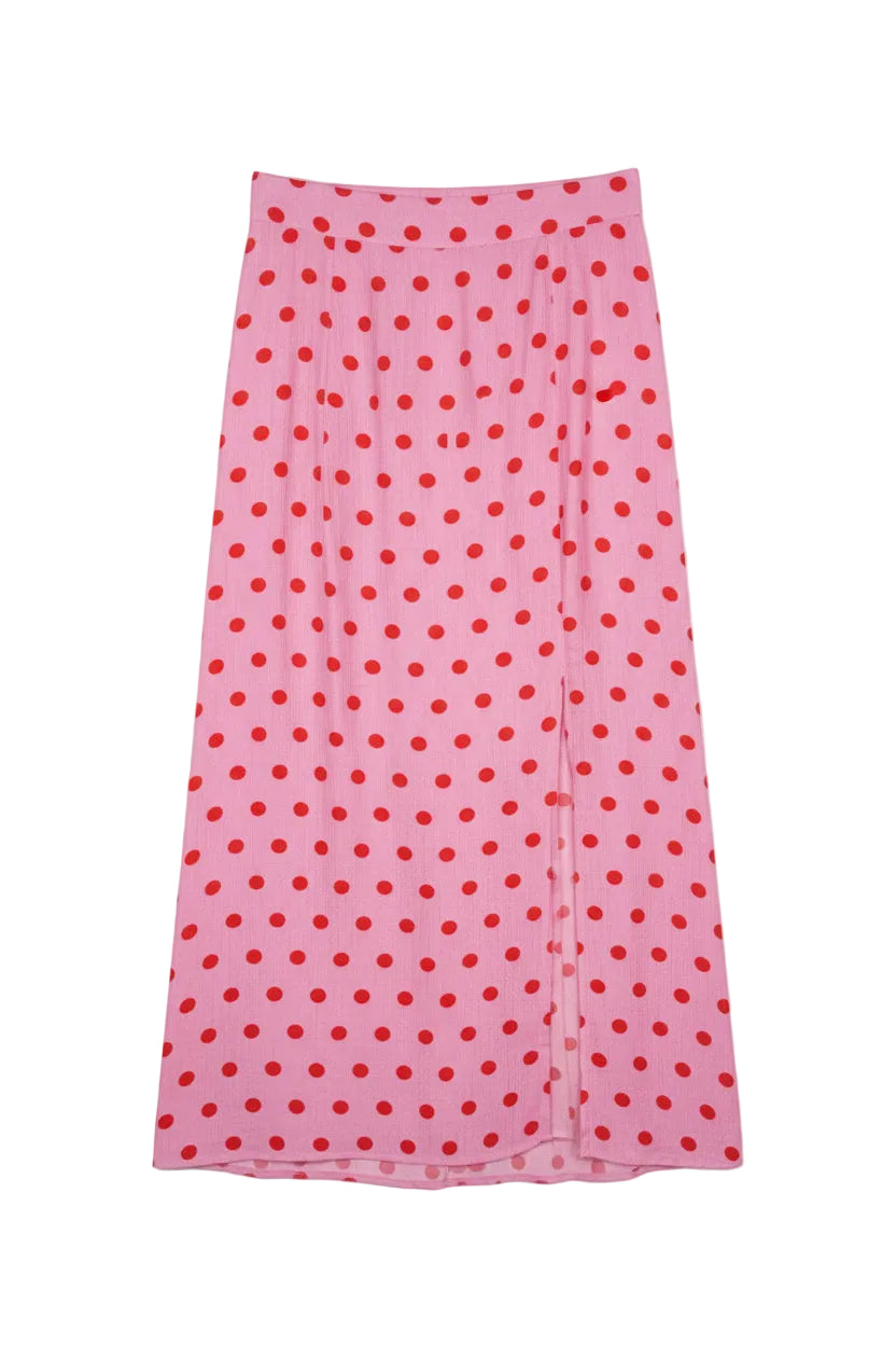 Pink skirt with red polka dots on a hanger against a white background