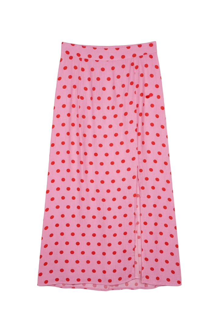 Pink skirt with red polka dots on a hanger against a white background