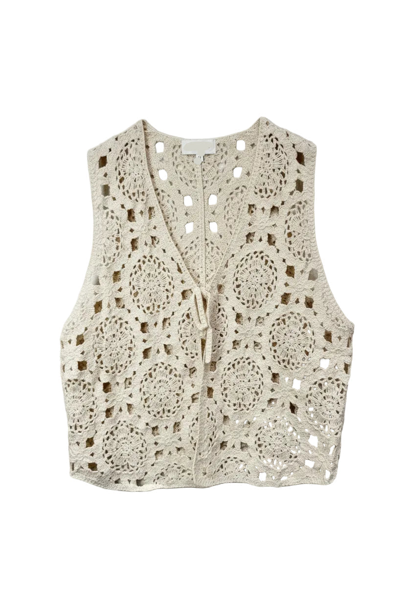 Beige crochet vest on a hanger against a light background