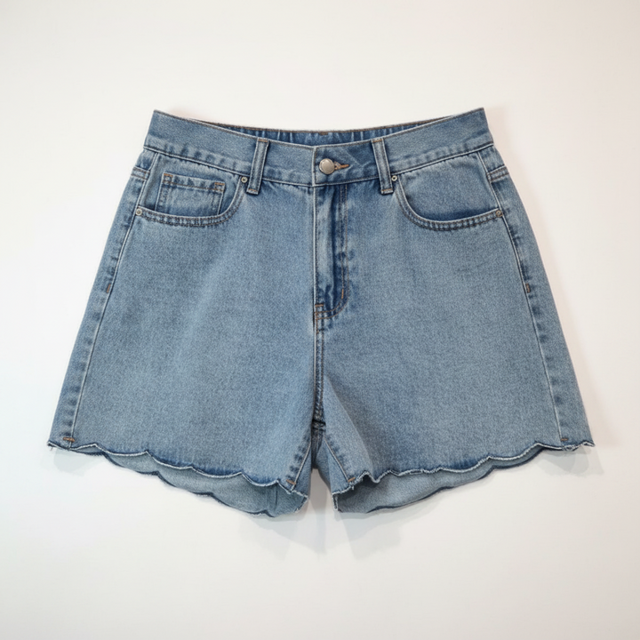 Blue denim shorts on a hanger against a beige wall