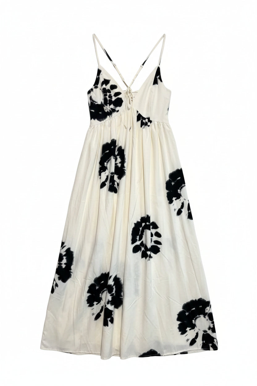 White dress with black floral patterns on a hanger against a white background