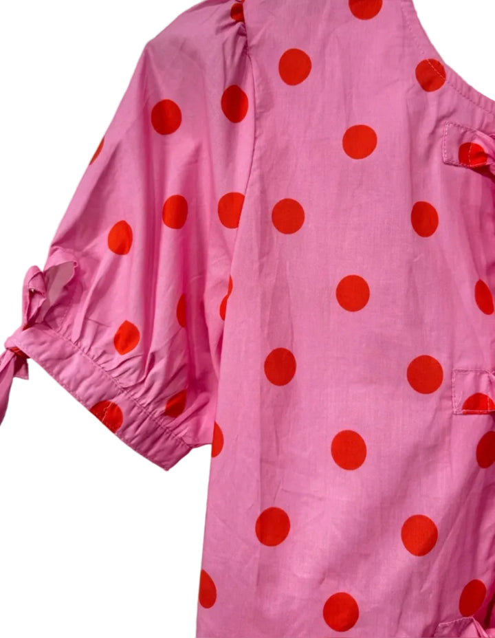 Pink garment with red polka dots on a white background