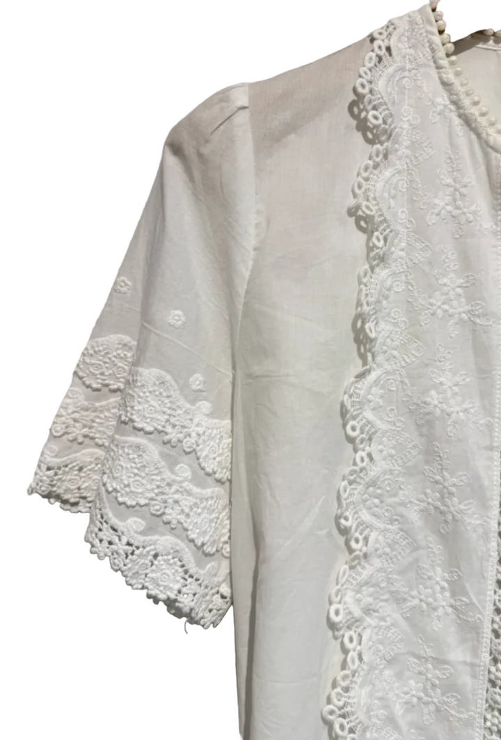 White lace-trimmed garment on a neutral background