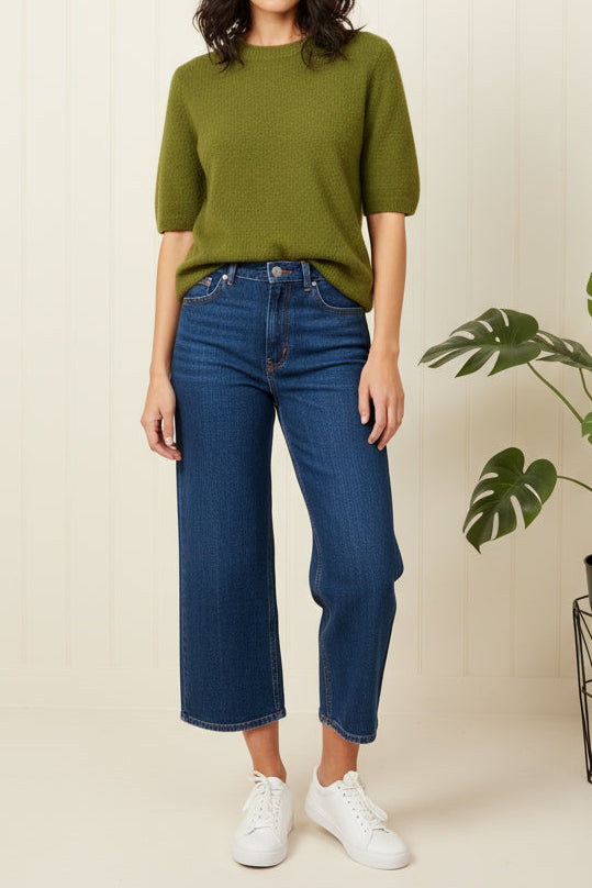 Green sweater on a white wooden surface
