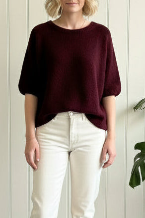 Person taking a mirror selfie in a store, wearing a dark top and light blue jeans.