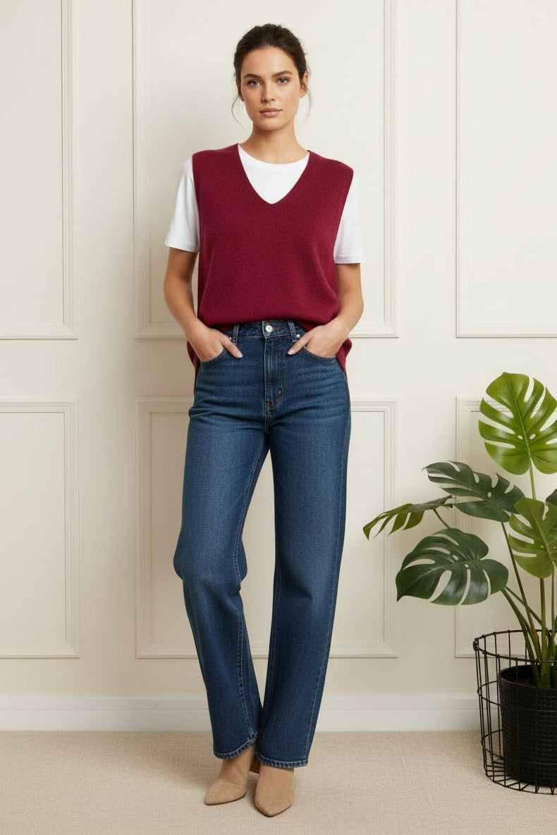 Maroon sweater on a hanger with jeans in the background