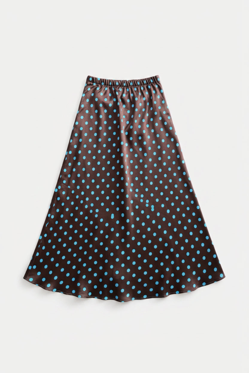 A black midi skirt with a blue polka dot pattern, hanging from a wooden hanger against a light gray background.