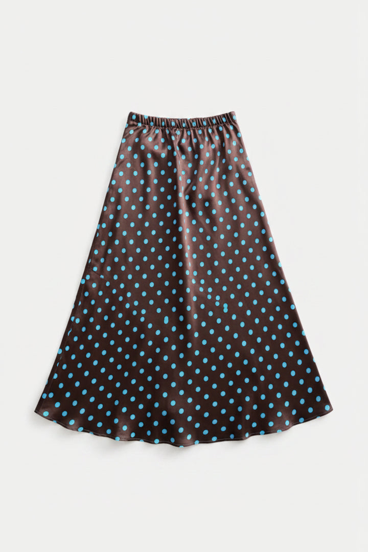 A black midi skirt with a blue polka dot pattern, hanging from a wooden hanger against a light gray background.