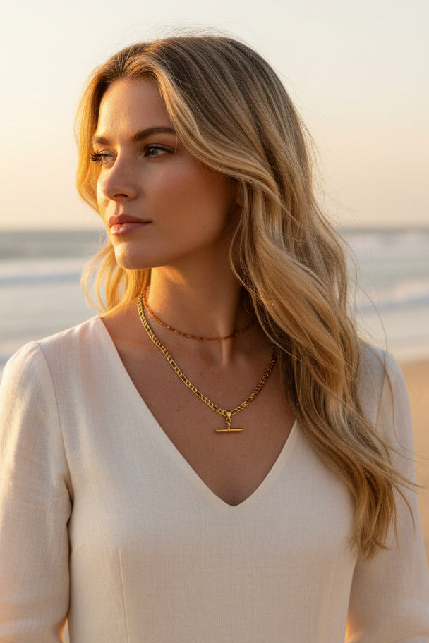 Gold chain necklace with a clasp on a person's neck