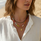 Woman wearing a colorful beaded necklace with a starfish charm against a neutral background