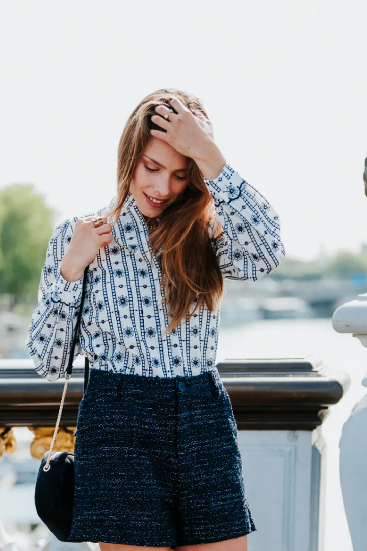 Woman posing on a bridge with a scenic background