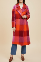 Woman wearing a colorful plaid coat on a white background