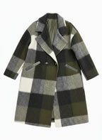 Folded plaid coat on a rack with a blurred background