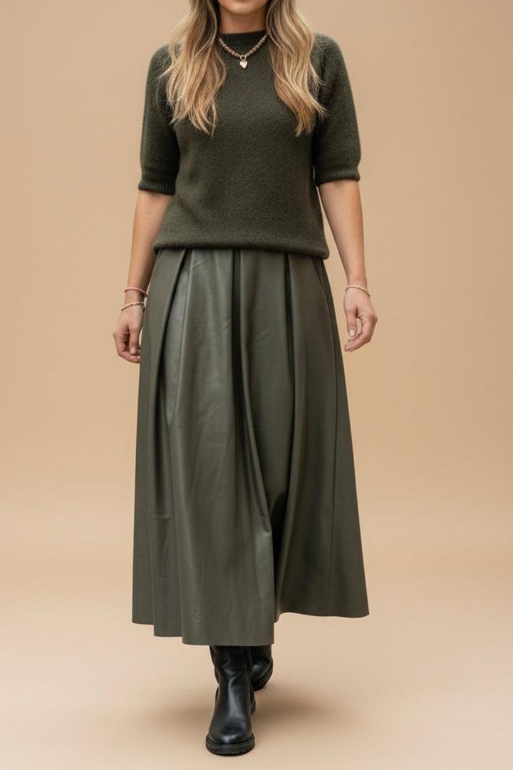 Person wearing a green top and skirt in a store setting