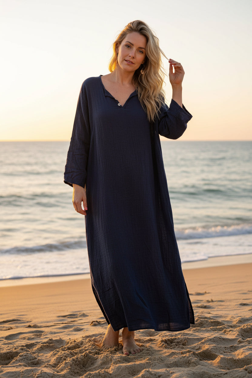 Woman wearing a navy blue dress with white sneakers indoors.