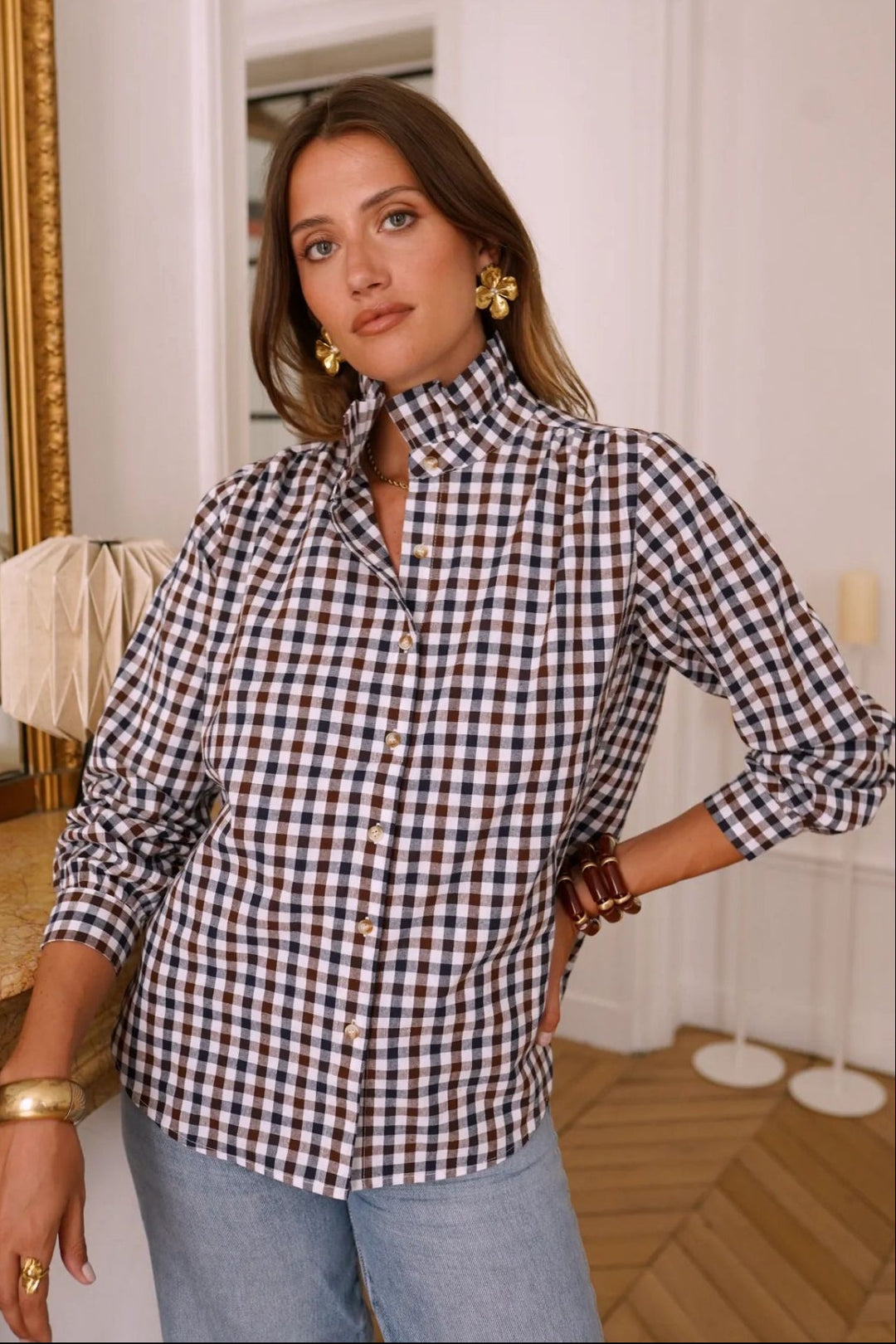 Woman wearing a black and white checkered shirt in an indoor setting
