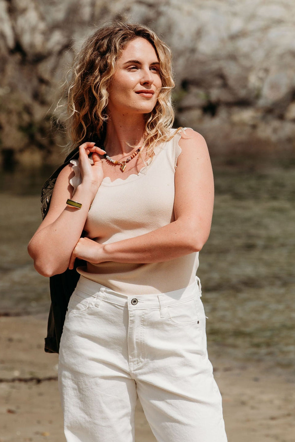 Woman standing on a beach with a scenic background