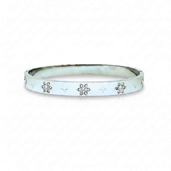 A silver-toned bangle bracelet with a smooth, polished finish, featuring small star engravings and three floral motifs set with clear rhinestones along the front edge, shown against a plain white background.