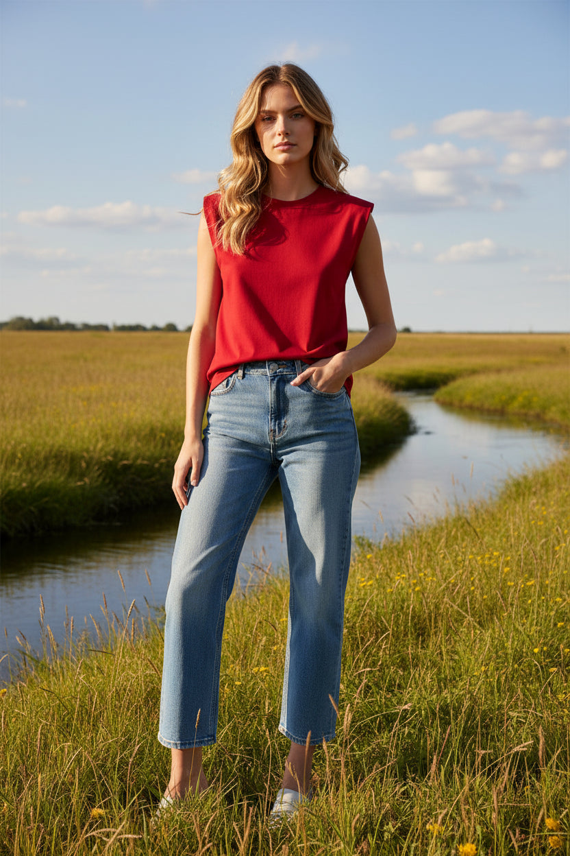 A sleeveless red t shirt with a crew neck, laid flat against a clean white background.