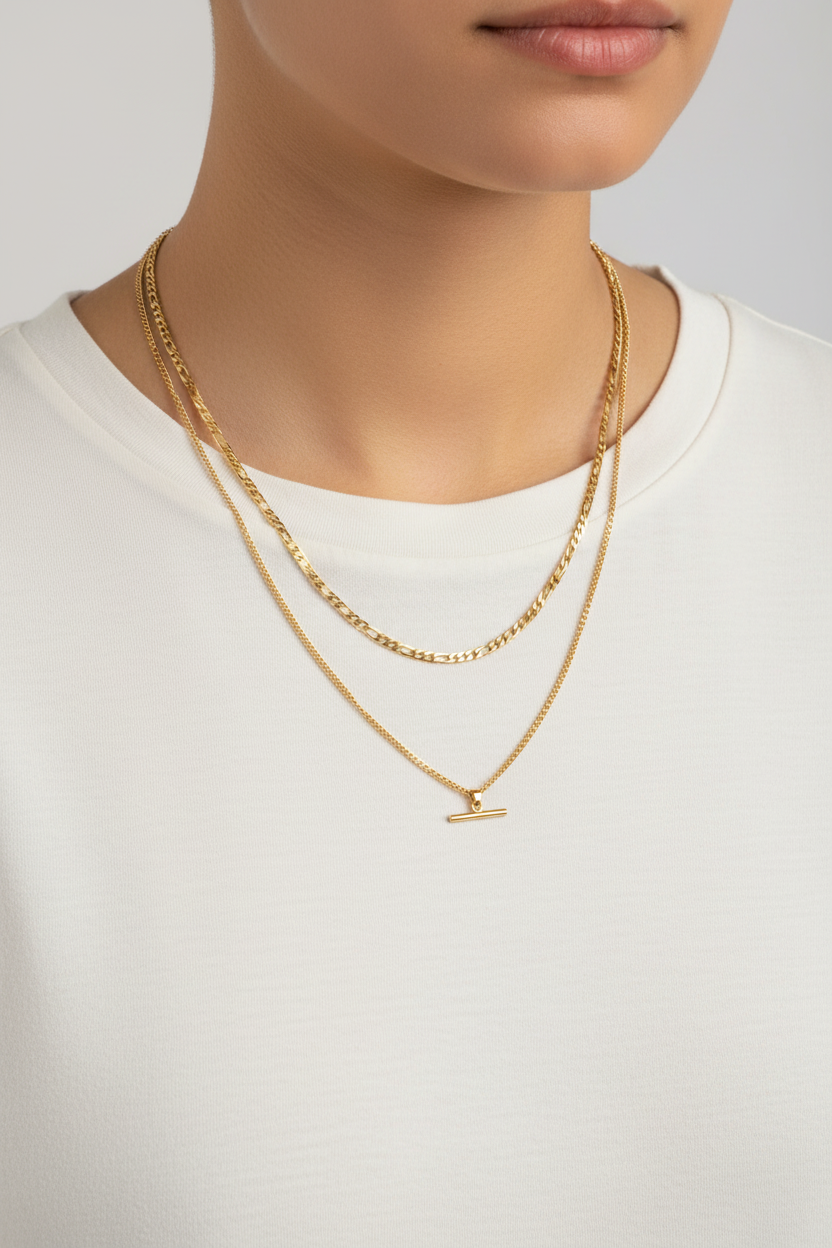 Gold necklaces on a person wearing a white shirt