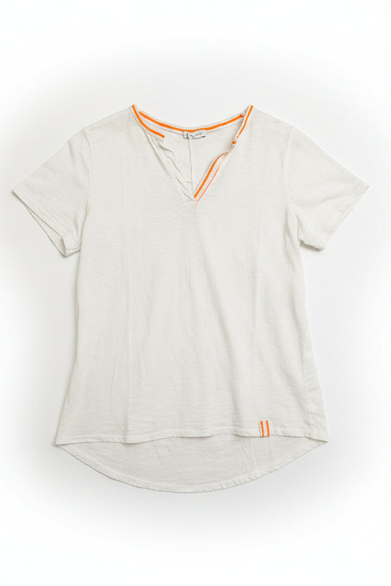 White t-shirt with orange accents on a hanger against a white wooden panel background
