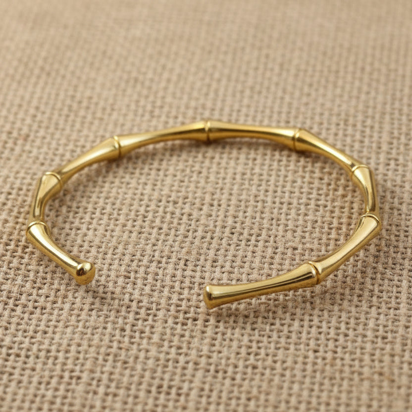 Gold bracelet on a light skin background