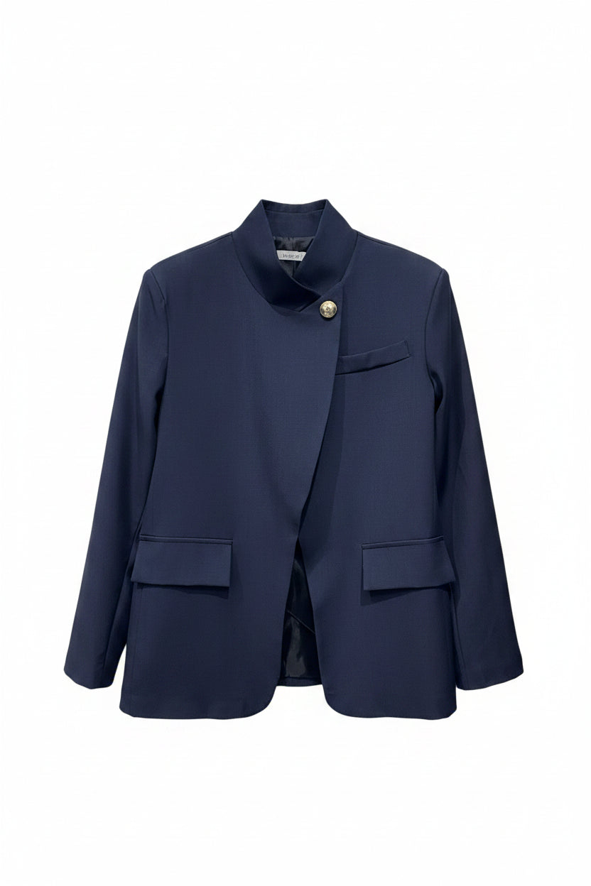 Navy blue blazer on a hanger against a white brick wall background