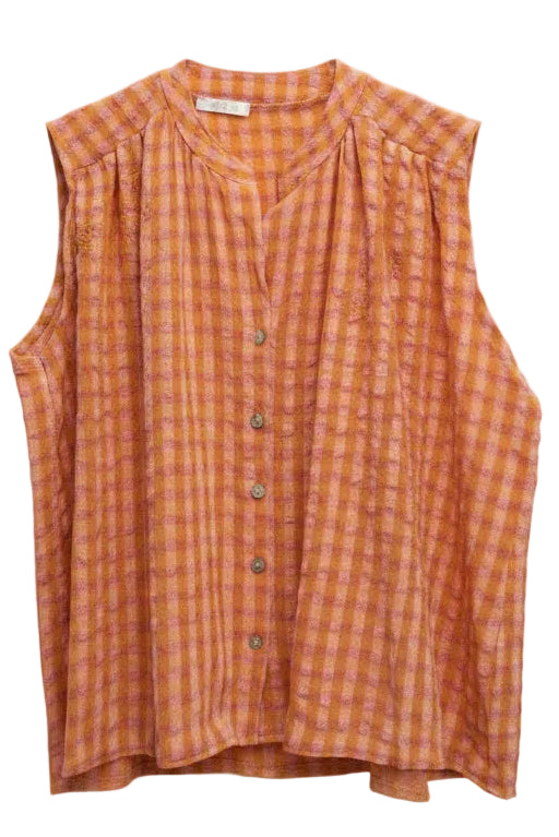 An orange and pink gingham sleeveless blouse hanging on a wooden hanger against a plain white wall.