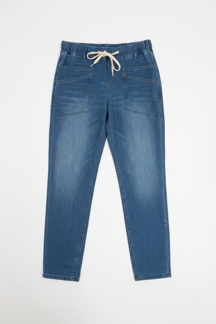 Pair of blue jeans on a hanger against a white wall